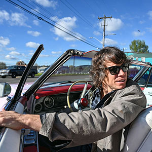 Charles at the wheel of the pink Cadillac